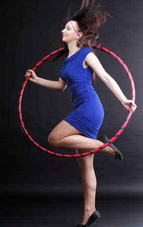 Beautiful woman in a sport wear. Dance hoop gym exercises black backgroundの写真素材
