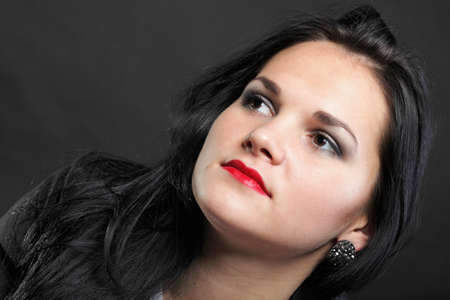 portrait of beautiful young brunette on black background.の写真素材