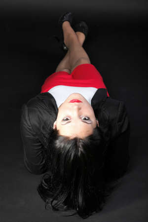 portrait of beautiful young brunette lies on black background.の写真素材