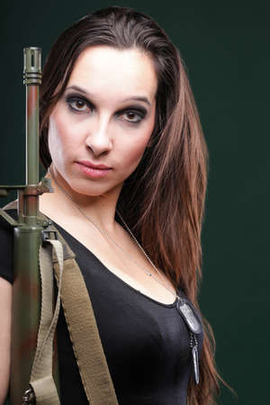 Military Army girl Holding Gun green backgroundの写真素材