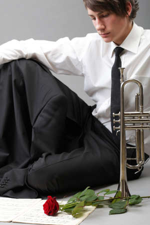 Portrait of a young jazz man andTrumpet grey background. Love melodyの写真素材