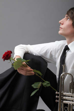 Portrait of a young jazz man andTrumpet grey background. Love melodyの写真素材