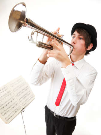 Portrait of a young jazz man playing his Trumpet white backgroundの写真素材