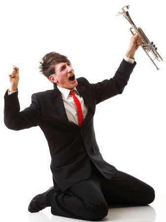 Portrait of a young jazz man joy, glee and his Trumpet white backgroundの写真素材