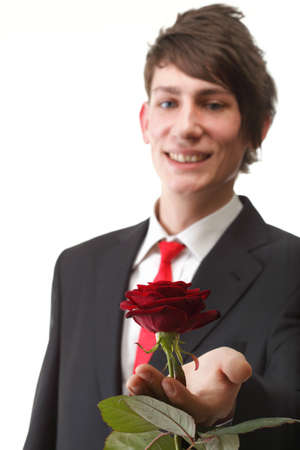 Young man presenting a flower - red rose isolated white backgroundの写真素材