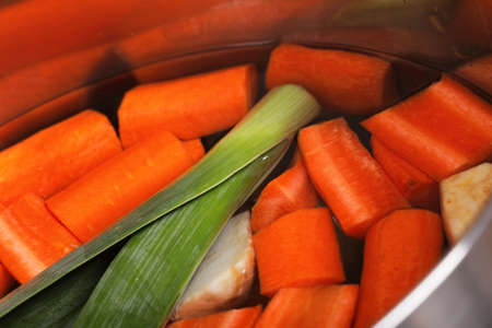 stainless steel pot with boiled carrot and vegetables soup の写真素材