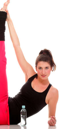beautiful young brunette woman stretching the muscles of her arms and back, isolated against white backgroundの写真素材