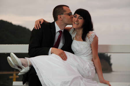 bride and groom, pier cloudy dusk sky.の写真素材