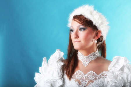 Beautiful ginger in white dress of Snow Queen blue backgroundの写真素材