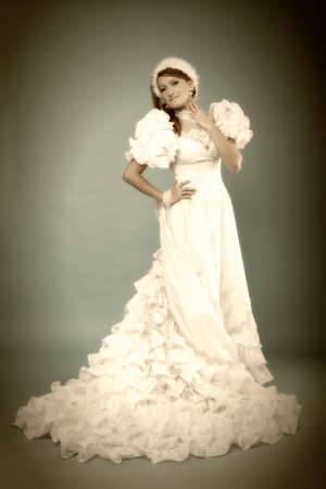 Beautiful ginger in white dress of Snow Queen blue backgroundの写真素材