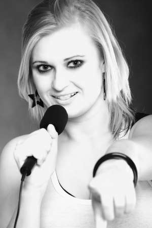 woman girl is singing rock song with a microphoneの写真素材