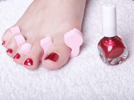 Close-up of female feet with red polished nails carefree, chiropodyの写真素材