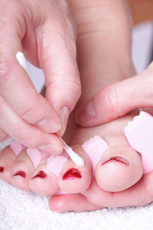 Close-up of female feet with red polished nails carefree, chiropodyの写真素材