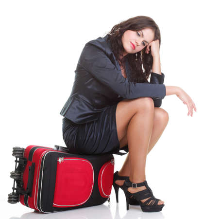 Full length of young business woman to late pulling red travel bag clock isolated on white backgroundの写真素材