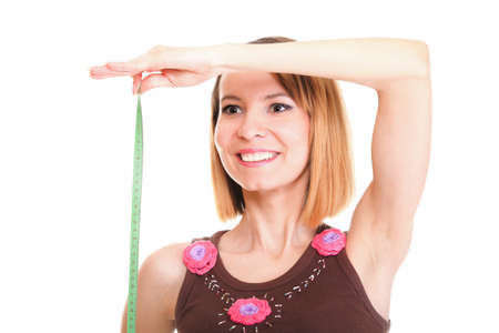 Beautiful young caucasian woman measuring her body with tape, isolated on white backgroundの写真素材