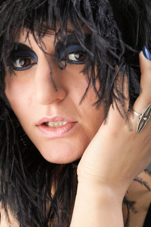 Beautiful Portrait of woman. Studio shot. Professional make up and hair style black feather