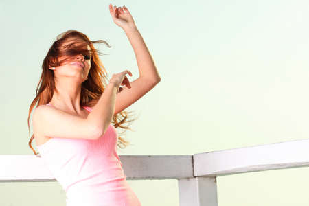 Attractive girl on pier winter in hair Young woman on background of sea skyの写真素材