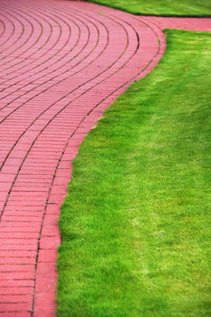 Garden stone path with grass growing up between and around stones, Brick Sidewalkの写真素材