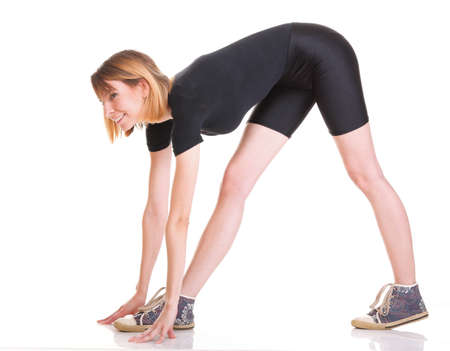 Sport Young woman in black doing exercise gymnastic pose isolated on whiteの写真素材