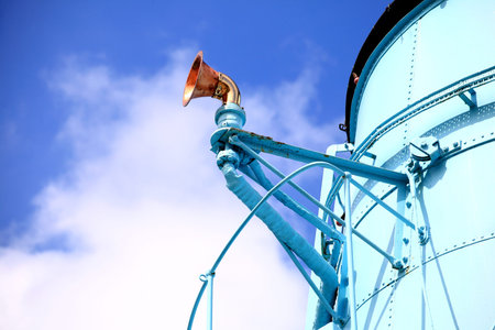 Funnel and whistle from a steamship against a grey sky