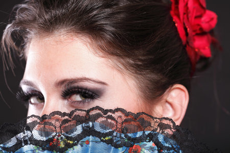 Attractive spanish dancer over black background young woman dancing flamenco