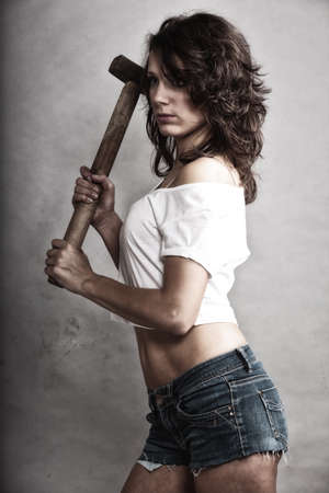 equality and feminism. Sexy girl holding hammer tool. Attractive woman working as repairman or mechanic.の写真素材