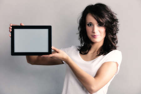 Technology. Sexy girl young attractive woman in summer clothes showing copy space on tablet touchpad.の写真素材