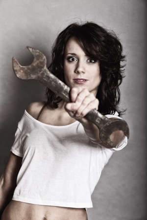 Sex equality and feminism. Sexy girl holding wrench spanner tool. Attractive woman working as repairman or mechanic.の写真素材