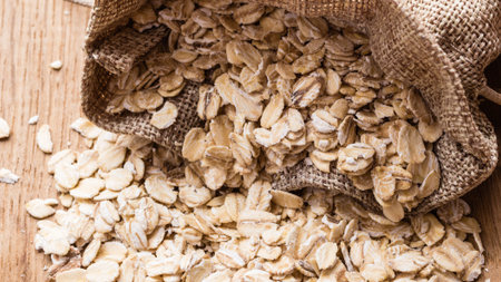Dieting. Oat cereal in burlap sack on wooden surface. Healthy food for lowering cholesterol, protect...