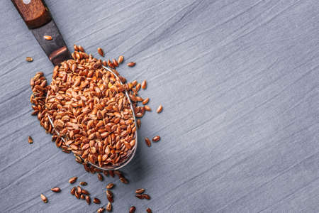 Healthy food. Flax seeds linseed on kitchen spoon linen gray color backgroundの写真素材