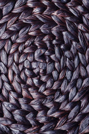 Closeup dark brown wicker woven pattern for abstract background or textureの写真素材