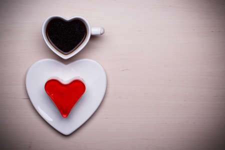 Heart shaped coffee cup and jelly cake on wooden surface, top view copy space for textの写真素材