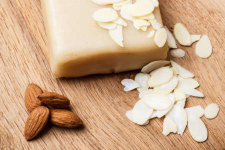 Whole food, good for health. Marzipan paste sliced blanched almonds and seeds on wooden kitchen board backgroundの写真素材