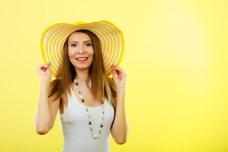Holidays and summer fashion. Woman in big yellow hat. Portrait of charming female on bright...
