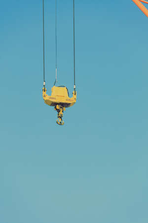 Business and commerce. Closeup crane hook at port area and blue sky, cargo container yard. Industrial sceneの写真素材