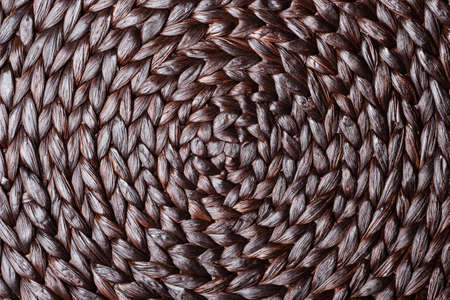 Closeup dark brown wicker woven pattern for abstract background or textureの写真素材
