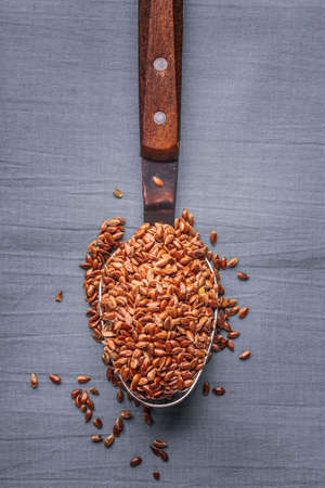 Healthy food. Flax seeds linseed on kitchen spoon linen gray color backgroundの写真素材