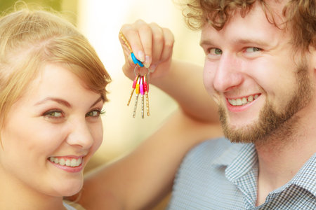 Real estate and family concept. Couple showing their new house keys