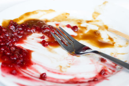 Food leftovers. An empty plate dirty after the meal is finished.