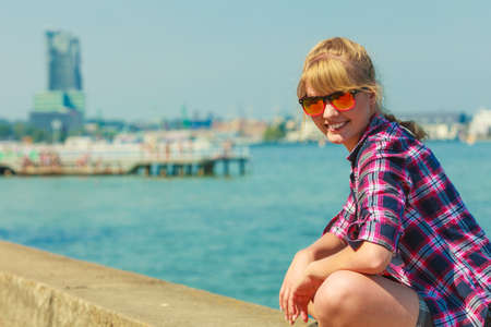 Summer vacation relax and traveling concept. Young tourist woman hiker relaxing on sea shore enjoying sunlightの写真素材