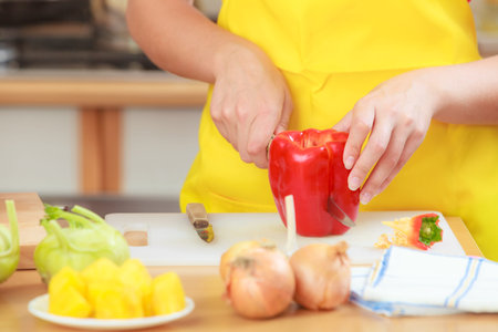 Healthy eating, vegetarian food, cooking, dieting and people concept. Woman in modern kitchen at...
