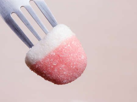 Sweet food. Pink gummy sweet jelly or marshmallow with sugar on fork closeup top viewの写真素材