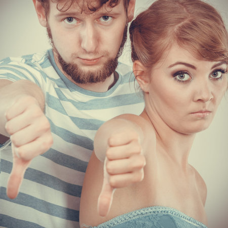 Couple doing bad sign showing thumbs up hand gesture