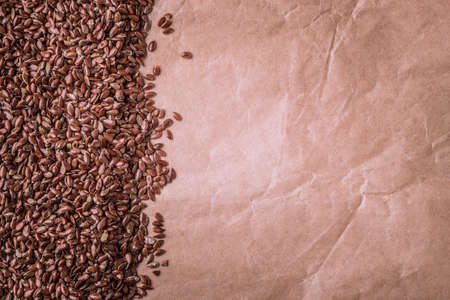 Healthy diet organic nutrition. Brown raw flax seeds linseed border frame on paper backgroundの写真素材