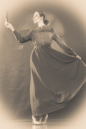 Vintage woman retro style dancing with black feather fan sepia tone