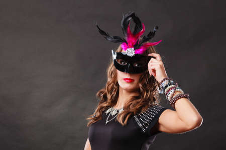 Holidays, people and celebration concept. Woman with carnival venetian mask on dark background.の写真素材