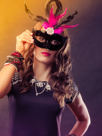 Holidays, people and celebration concept. Woman with carnival venetian mask on colorful background.の写真素材