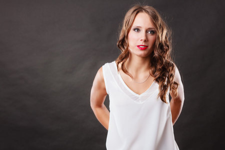 Elegant woman curly hair white blouse portrait on black