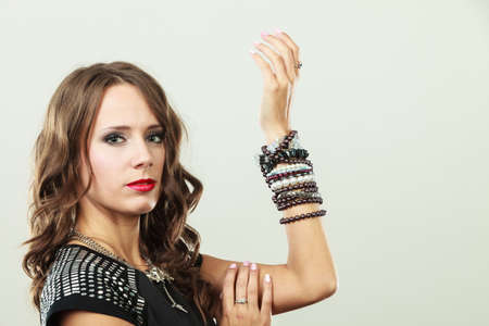 Pretty young woman wearing multiple bracelets jewellery necklace in black elegant evening dress, copy space text areaの写真素材