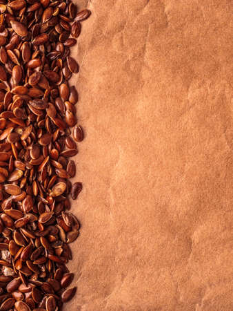 Healthy diet organic nutrition. Brown raw flax seeds linseed border frame on paper backgroundの写真素材